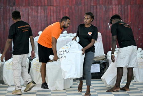 Electoral officers carry ballot boxes for counting after elections in Solomon Islands, where pro-China Prime Minister Manasseh Sogavare was reported to have retained his seat