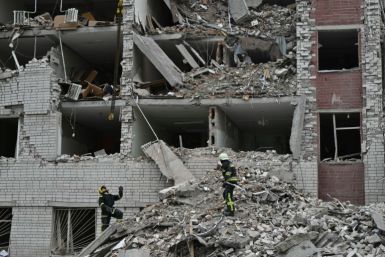 Ukrainian rescuers clear the rubble of a destroyed building following a missile attack in Chernigiv on April 17, 2024