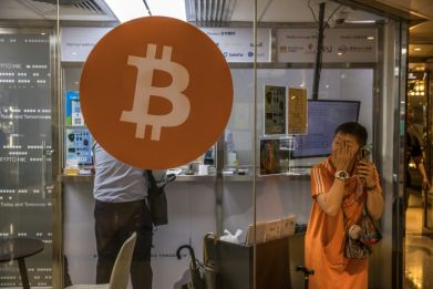 A woman uses her phone outside a cryptocurrency exchange in Hong Kong