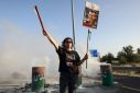 A woman holds a poster of Israeli hostage Dror Or as relatives and supporters of captives held by militants in Gaza block a highway between Tel Aviv and Jerusalem to protest for their release
