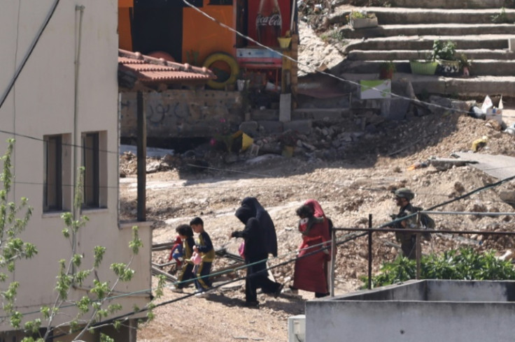 Israeli soldiers lead a Palestinian family out of their home during a 40-hour-long raid in the Nur Shams refugee camp in the occupied West Bank