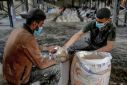 Workers ration out flour during the distribution of humanitarian aid in Gaza City