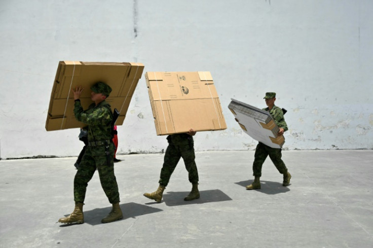 Ecuadoran soldiers carry electoral material at a school in Quito on April 20, 2024, on the eve of a referendum on tougher measures against organized crime