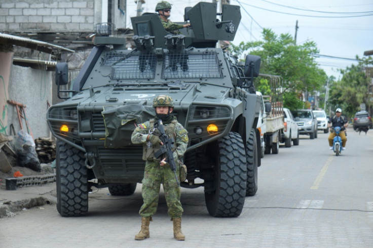 Soldiers stand guard outside a polling station as Ecuadoran voters cast ballots on tougher measures against crime