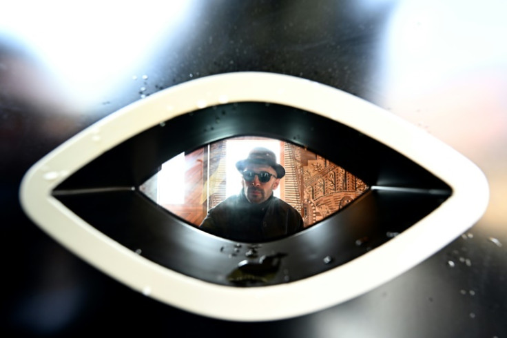 French artist JR is pictured through the window of a carriage-sized suite called L'Observatoire onboard the Venice Simplon-Orient-Express  on the sidelines of the show