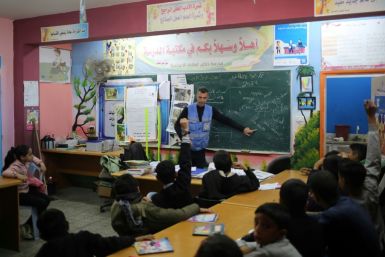 Ismail Wahba, director of the UNRWA Taif School in Rafah, teaches an English class in the library of a school housing displaced Palestinians in Rafah