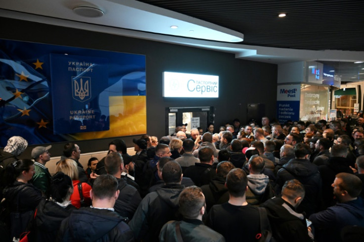 Ukrainians gathered at a closed Ukrainian passport service point at a shopping center in Warsaw on Wednesdayin Warsaw were angry at Kyiv's decision to suspend consular services