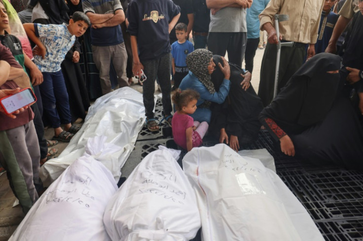 Palestinians at Al-Najjar Hospital, Rafah, mourn beside the bodies of relatives killed in Israeli bombardment