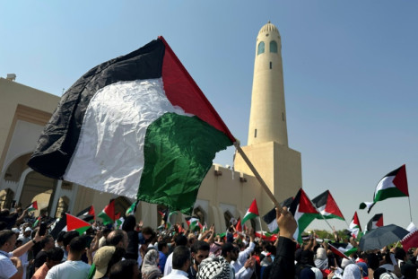 People wave the Palestinian flag during protests in Doha after the outbreak of the Gaza war