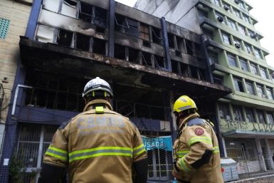 Firefighters work at the site where a homeless shelter caught fire, killing at least 10 people, in Porto Alegre, Brazil