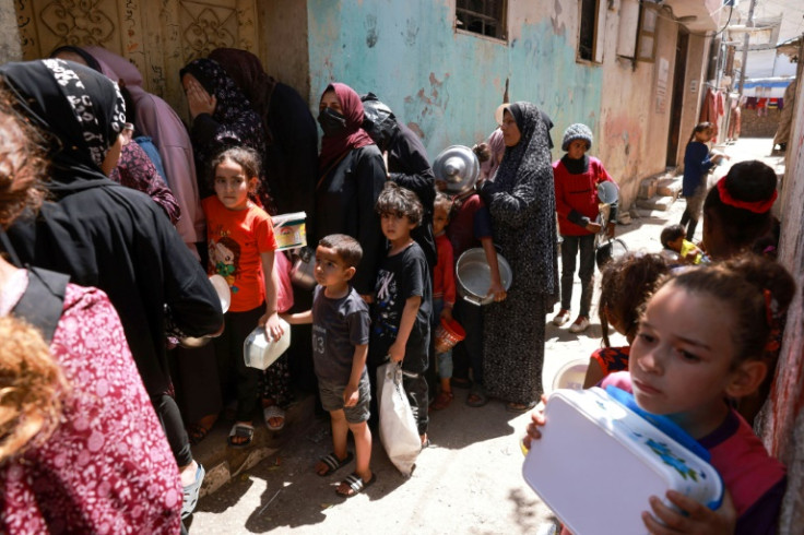 Displaced Palestinian children line up to receive food in Rafah