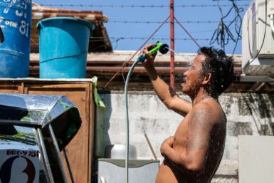 A man showers with a hose during hot weather in Manila on April 28, 2024