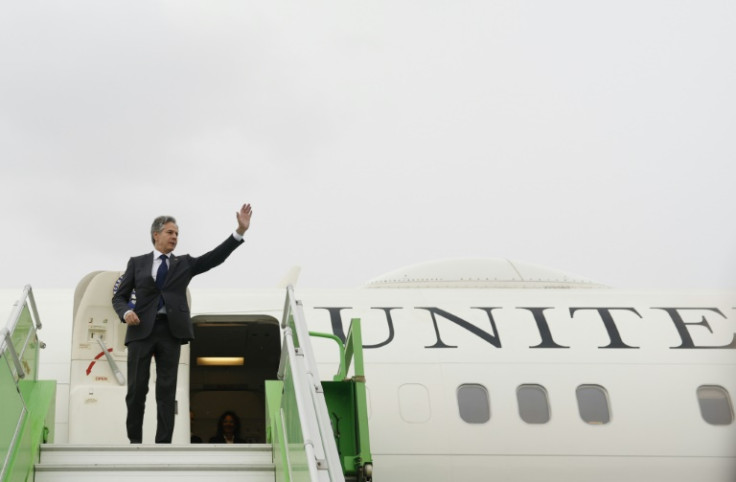US Secretary of State Antony Blinken waves while boarding a plane from Saudi Arabia to Jordan