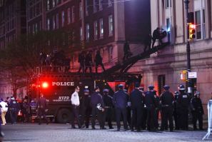 NYPD officers in riot gear break into a building at Columbia University, where pro-Palestinian students are barricaded inside a building and have set up an encampment, in New York City