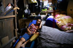 Richel Mangampo (L) sleeps beside her children Jalian and Sherwin at their house in Manila