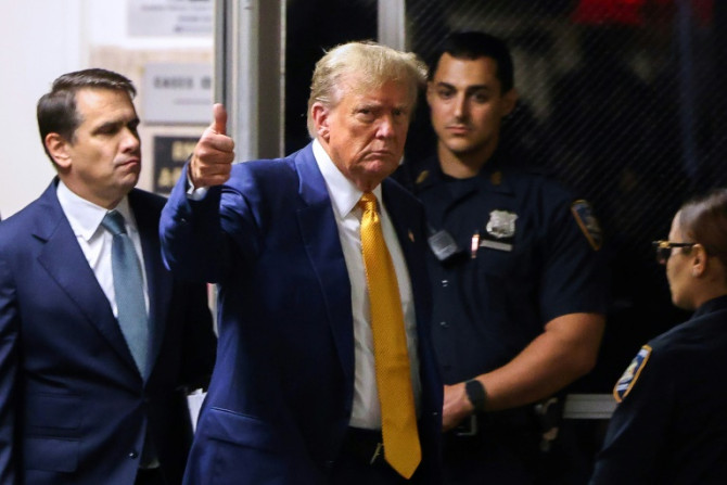Trump gives a thumbs-up gesture as he returns to court after a break in his hush money trial