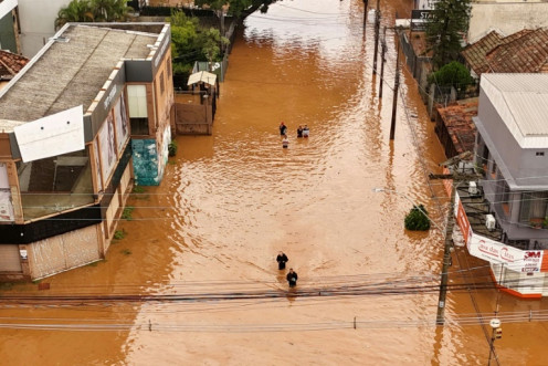 Aerial view of people walking through a flooded street at the Navegantes neighborhood in Porto Alegre, Rio da Grande do State, Brazil