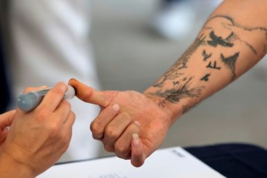 An inmate voting in Mexico's presidential election has his thumb inked at a jail in Puente Grande, Jalisco state