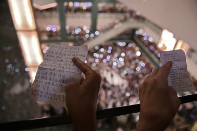 People hold the lyrics to 'Glory to Hong Kong’ at a shopping mall during the city's 2019 democracy protests