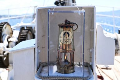 The Olympic flame pictured on board the 19th-century three-masted ship Belem off the coast of Marseille