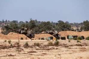 Israeli troops man a position with mobile artillery units in southern Israel near the border with the Gaza Strip