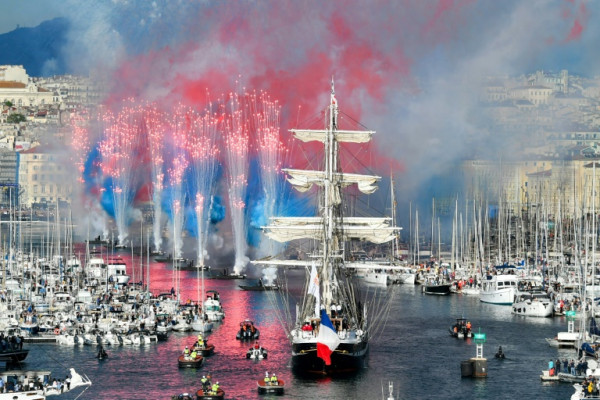 Fireworks go off as the 19th century Belem sailing ship carries the Olympic flame into Marseille's Old Port