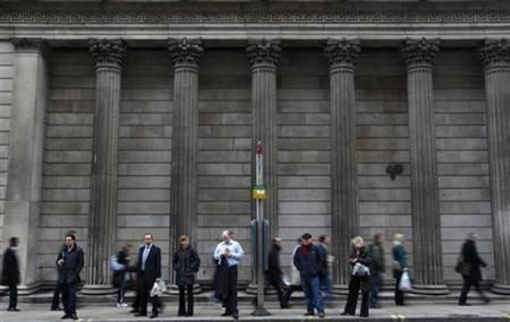 People wait at a bus stop outside the Bank of England in central London