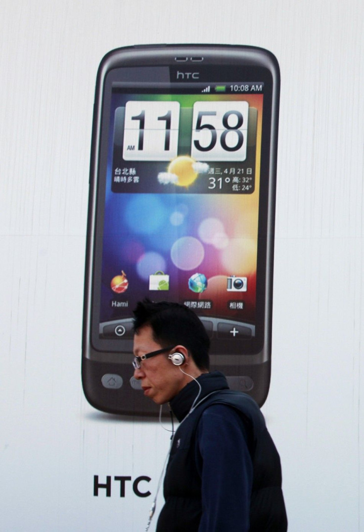 A man walks past a HTC advertisement in Taipei