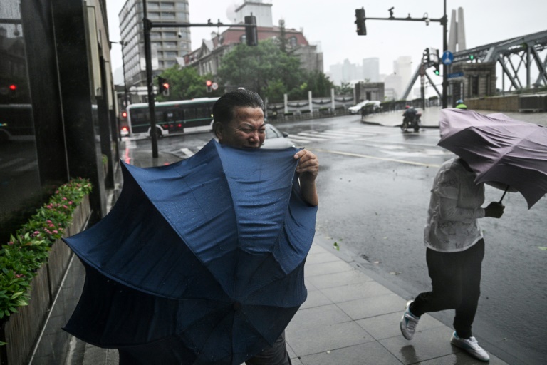 https://d.ibtimes.com/en/full/4548168/pedestrians-struggle-their-umbrellas-strong-winds-rain-passage-typhoon-bebinca-shanghai.jpg