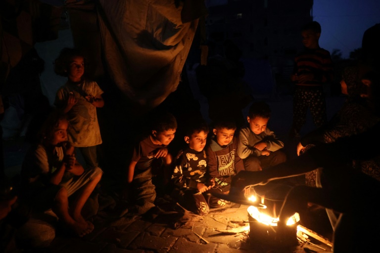 https://d.ibtimes.com/en/full/4557293/palestinian-children-sitting-around-fire-rubble-gaza.jpg