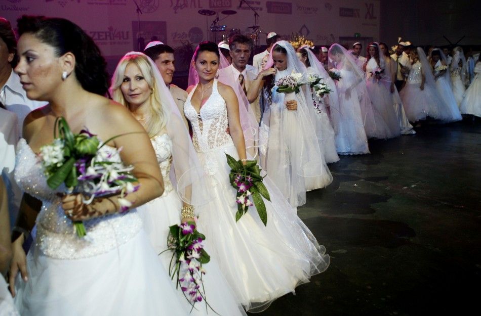 Brides and grooms take part in a mass wedding for 32 couples from areas of northern Israel skirting the Lebanese frontier, in Tel Aviv August 14, 2006.