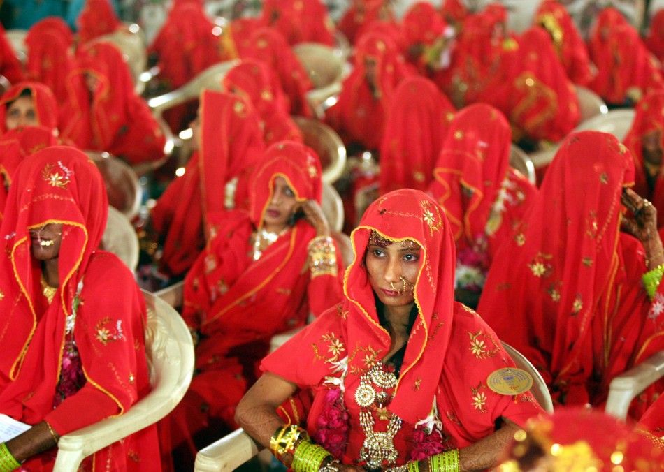 Indian Muslim brides sit during a mass wedding ceremony in the western Indian city of Ahmedabad March 10, 2007. A total of 163 Muslim couples from various city slums of Ahmedabad took wedding vows during the two days mass marriage ceremony organized by a 