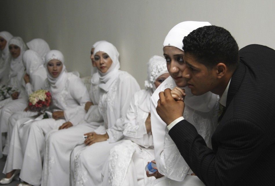 A Palestinian bride poses for a picture with her groom during a group wedding ceremony in Sidon, southern Lebanon, July 18, 2010. Fifty Palestinian couples participated in the group wedding ceremony organized by the Hamas movement in Lebanon.