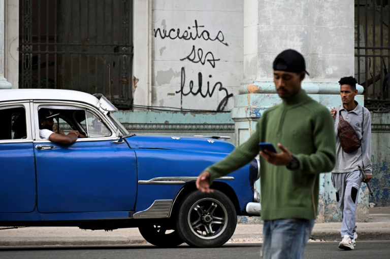 https://d.ibtimes.com/en/full/4572779/cubans-walk-past-graffiti-havana-telling-them-you-need-happy.jpg