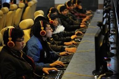 A man smokes while using a computer at an Internet cafe in Taiyuan