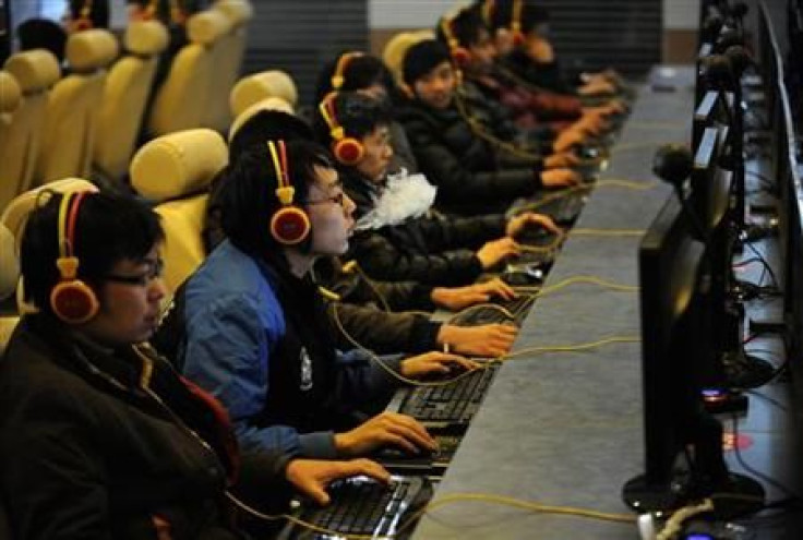 A man smokes while using a computer at an Internet cafe in Taiyuan