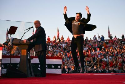 Tesla CEO Elon Musk jumps on stage as he joins Donald Trump, then the Republican candidate for president, during a campaign rally at site of his first assassination attempt in Butler, Pennsylvania in October 2024