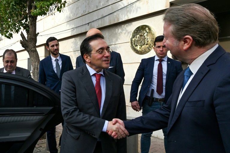 https://d.ibtimes.com/en/full/4575815/spains-foreign-minister-jose-manuel-albares-l-shakes-hands-official-outside-madrids-reopened.jpg