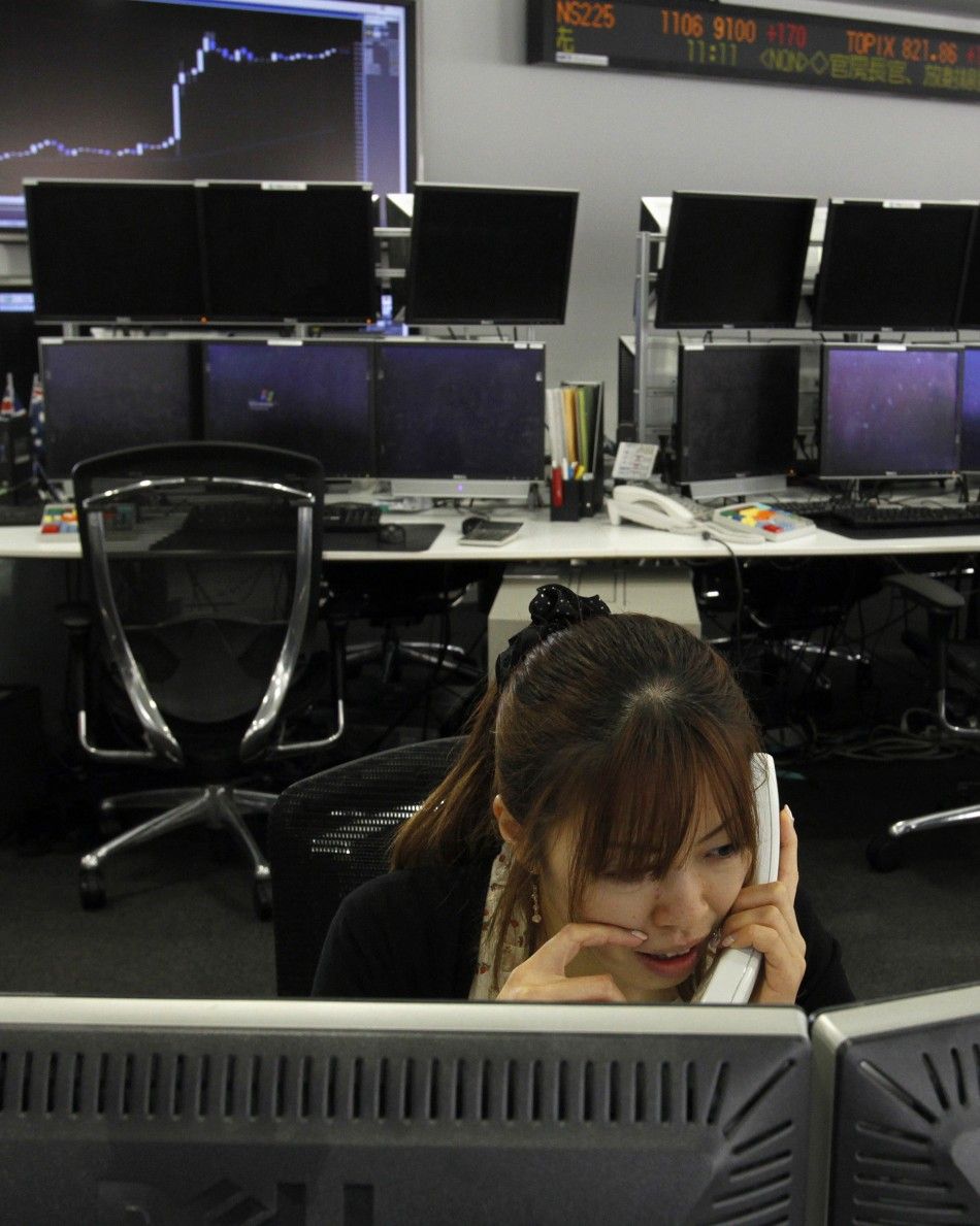 An employee talks on a phone at a foreign currency trading company in Tokyo