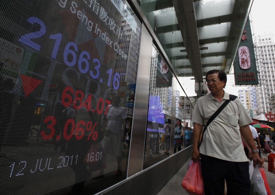 A passerby looks at the closing Hang Seng Index displayed outside a bank in Hong Kong