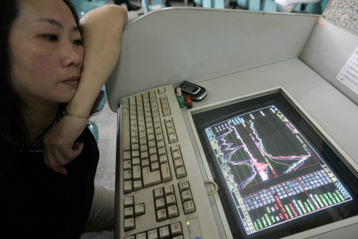 A woman watches the Shanghai Composite Index on computer screen in Shanghai