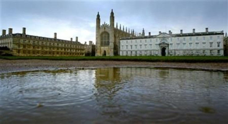 Rain drops break the surface of a puddle at the rear of Kings&#039; College in Cambridge
