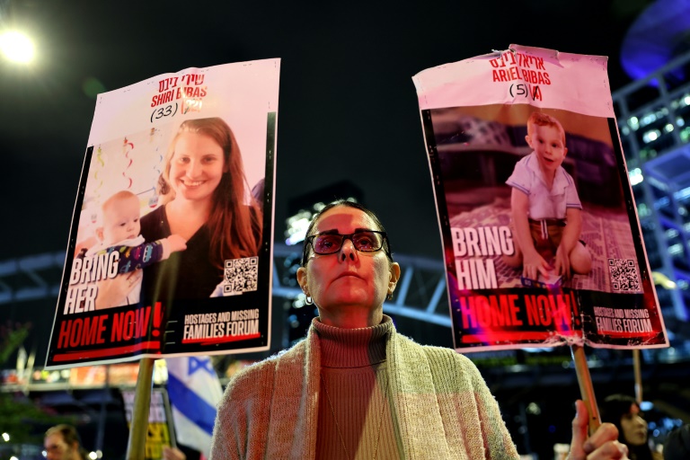 https://d.ibtimes.com/en/full/4583690/demonstrator-tel-aviv-holds-placards-bearing-pictures-members-bibas-family.jpg