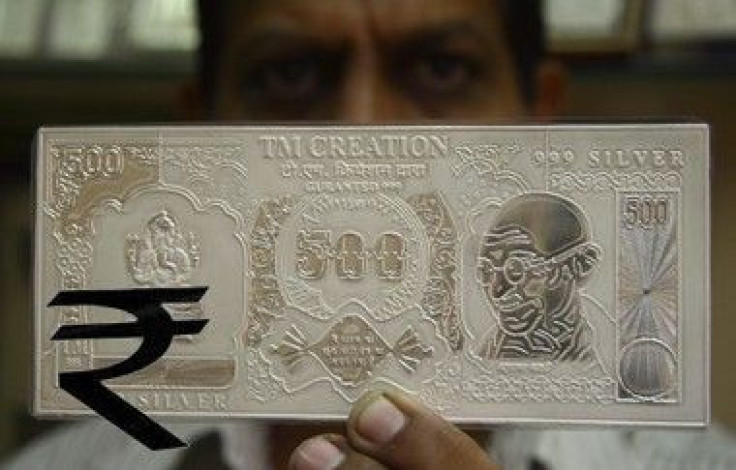 A jeweller displays a silver plate in the form of an Indian rupee note in this file photo. 