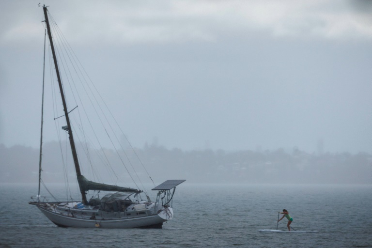 https://d.ibtimes.com/en/full/4585195/woman-paddles-past-yacht-wellington-point-brisbane-march-5-2025-tropical-cyclone-alfred.jpg