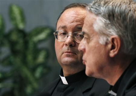 Monsignor Scicula, a Vatican doctrinal official, watches as Vatican's spokesman Father Lombardi speaks at the Vatican