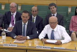 News Corp Chief Executive and Chairman Rupert Murdoch sits without his jacket after being attacked with a plate of white foam, during a parliamentary committee hearing at Portcullis House in London