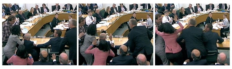 Wendi Deng unges towards a man trying to attack her husband, News Corp Chief Executive and Chairman Rupert Murdoch, during a parliamentary committee hearing on phone hacking at Portcullis House in London