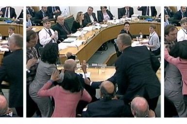 Wendi Deng unges towards a man trying to attack her husband, News Corp Chief Executive and Chairman Rupert Murdoch, during a parliamentary committee hearing on phone hacking at Portcullis House in London