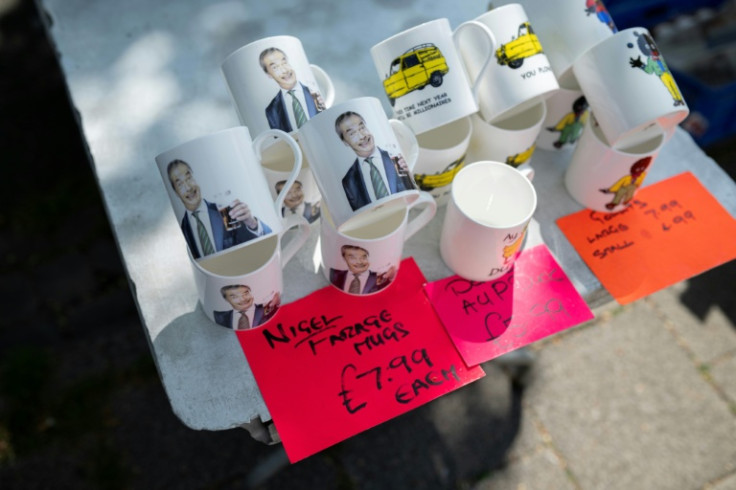 Mugs bearing the image of Reform UK party leader Nigel Farage are displayed on a stall on a street market in Frodsham, near Runcorn, northwest England, where Reform has been pushing hard to oust Labour and win a parliamentary by-election